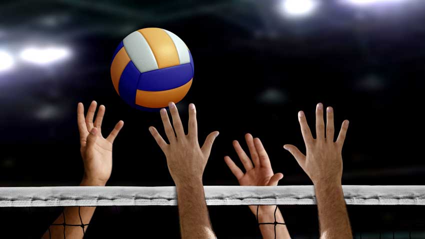 hands of volleyball players hitting the ball at the net